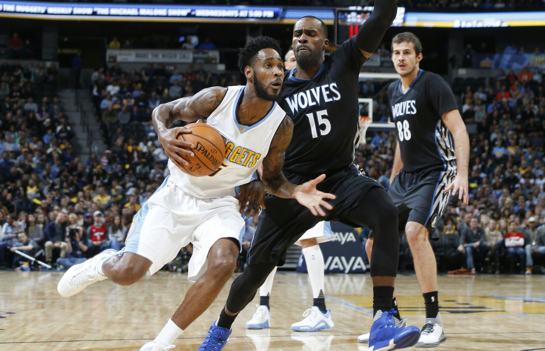 Denver Nuggets guard Will Barton, left, drives to shoot past Minnesota Timberwolves forward Shabazz Muhammad during the first half of an NBA basketball game Friday, Oct. 30, 2015, in Denver. (AP Photo/David Zalubowski)