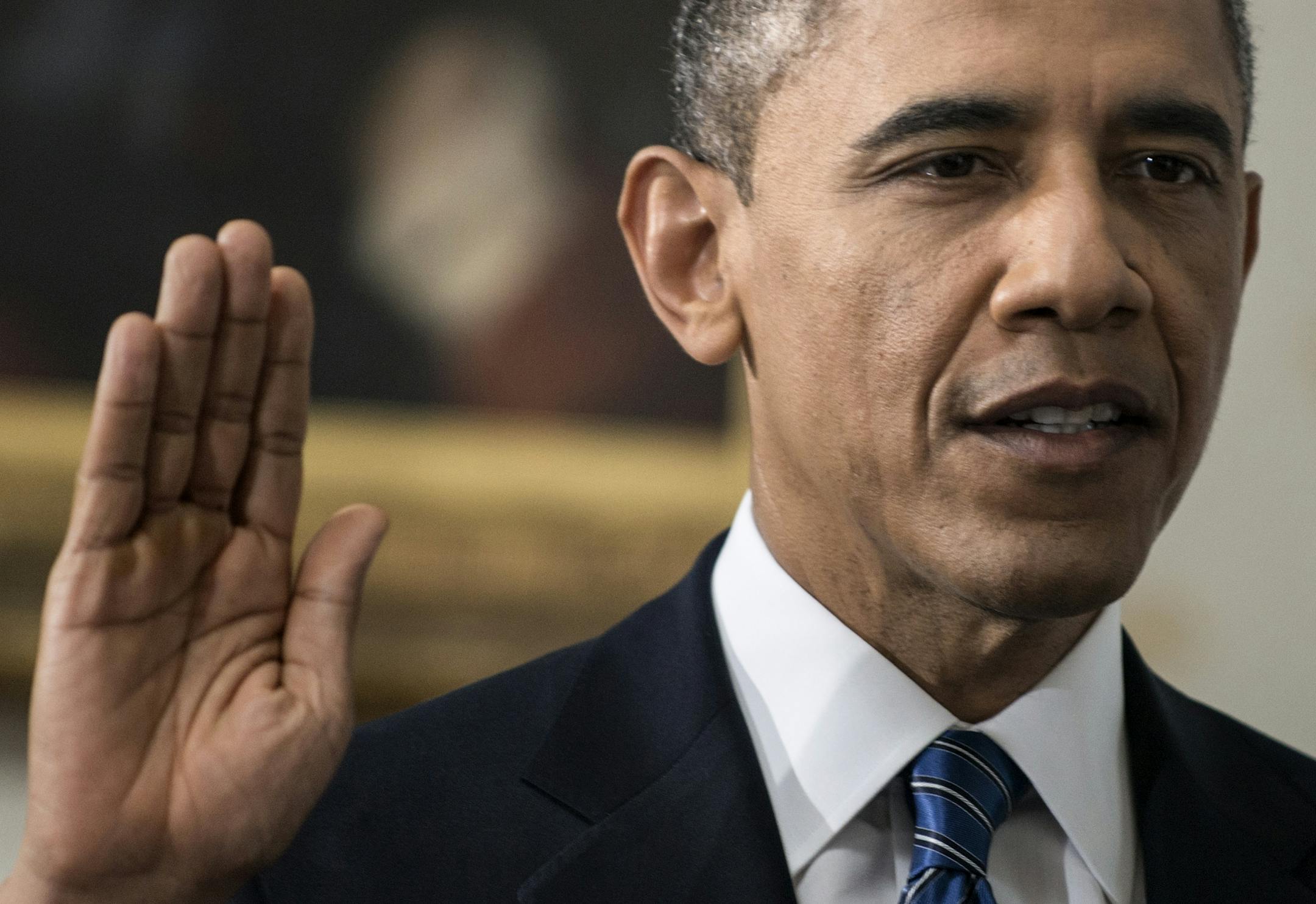 President Barack Obama is officially sworn-in by Chief Justice John Roberts, not pictured, in the Blue Room of the White House during the 57th Presidential Inauguration in Washington, Sunday, Jan. 20, 2013.