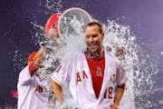 Los Angeles Angels' David Murphy, center, is doused with liquid by teammates Taylor Featherston, left, and Matt Joyce after Murphy hit a walk-off sing
