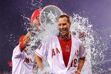 Los Angeles Angels' David Murphy, center, is doused with liquid by teammates Taylor Featherston, left, and Matt Joyce after Murphy hit a walk-off sing