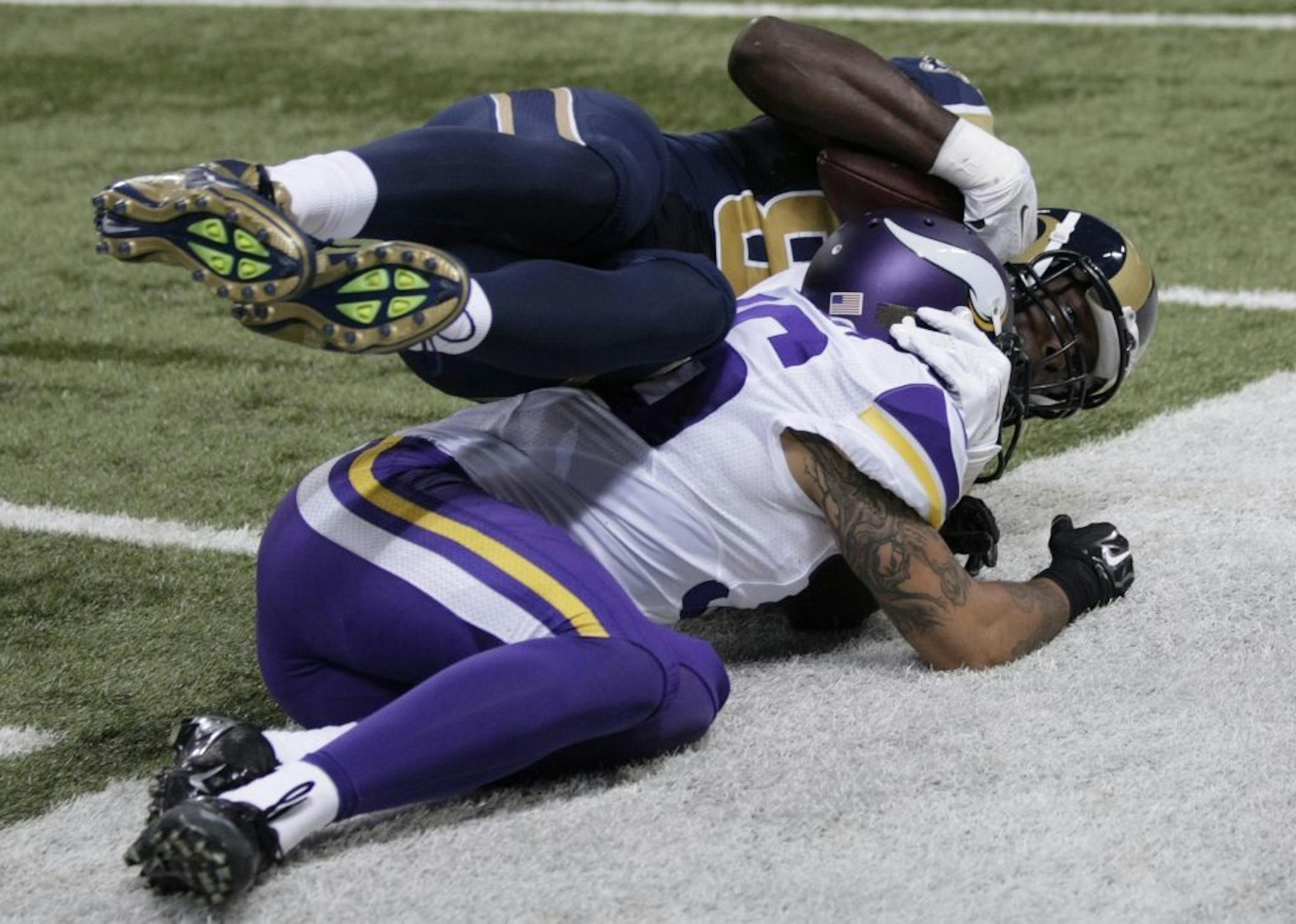 St. Louis Rams tight end Jared Cook, top, falls after catching a pass for a 26-yard gain as Minnesota Vikings defensive back Robert Blanton defends during the third quarter an NFL football game Sunday, Sept. 7, 2014, in St. Louis.