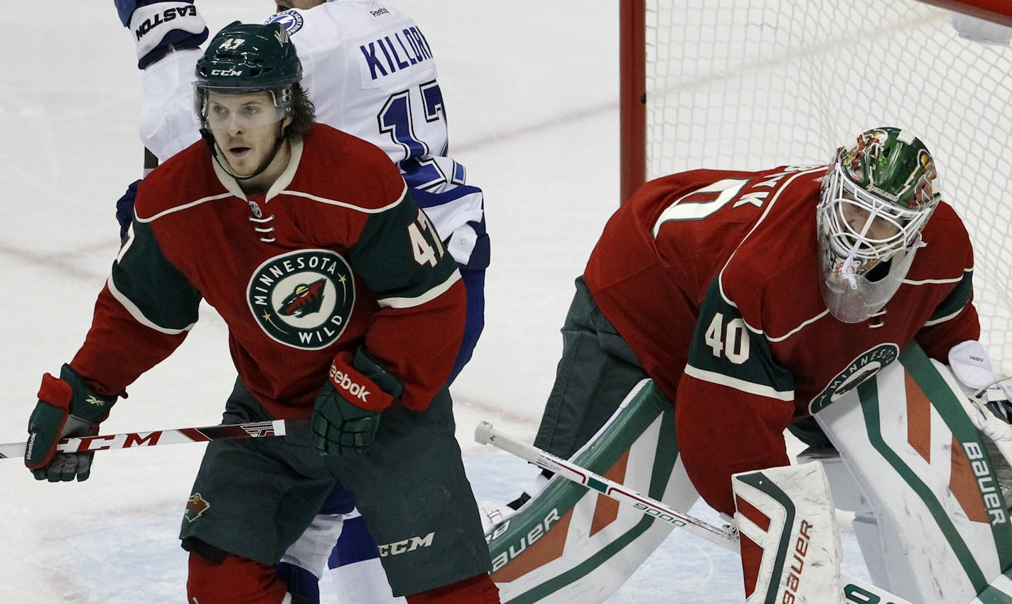 Minnesota Wild center Christoph Bertschy, left, of Switzlerand, holds back Tampa Bay Lightning center Alex Killorn (17) as Wild goalie Devan Dubnyk (40) keeps his eyes on the puck during the first period of an NHL hockey game in St. Paul, Minn., Saturday, Nov. 7, 2015. (AP Photo/Ann Heisenfelt) ORG XMIT: MIN2015111212251626