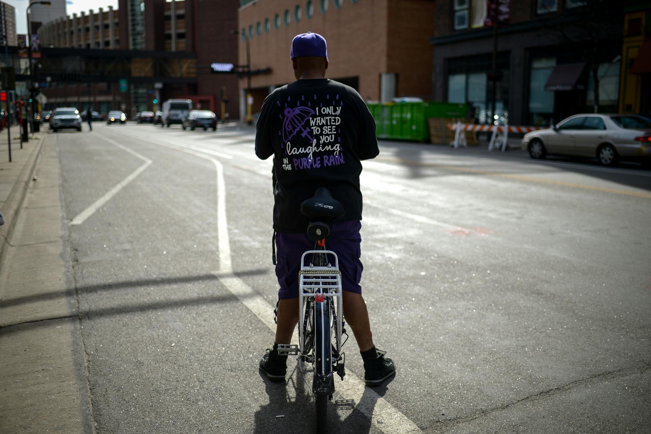 Michael Walker, of Minneapolis, checked photos on his phone before taking off from the Prince memorial at First Avenue with his dog, Nikko, Friday afternoon.