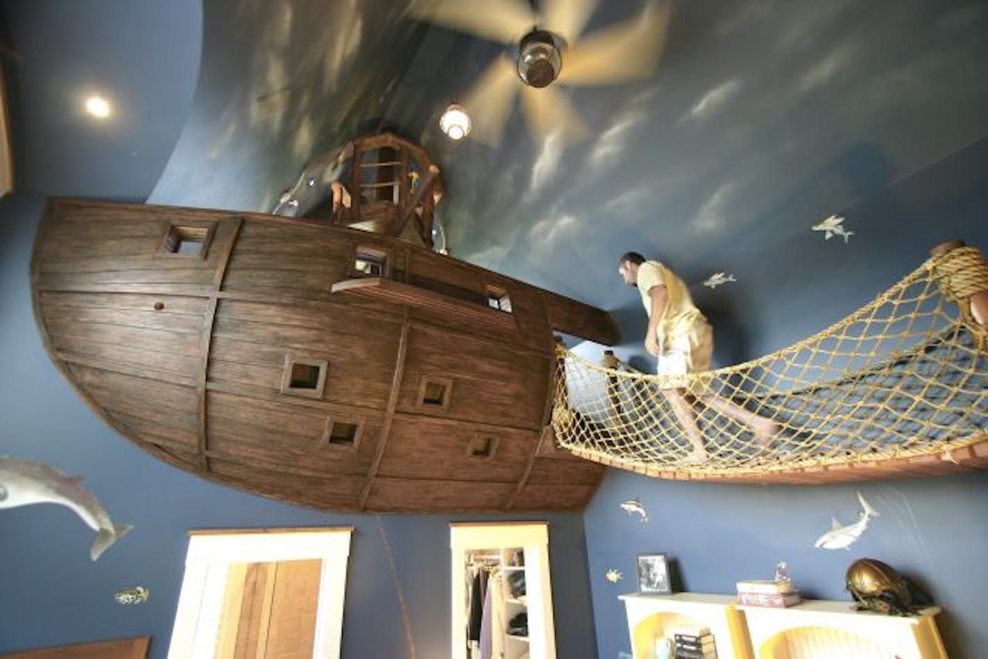 A rope bridge leads into a ship in this pirate-themed bedroom.