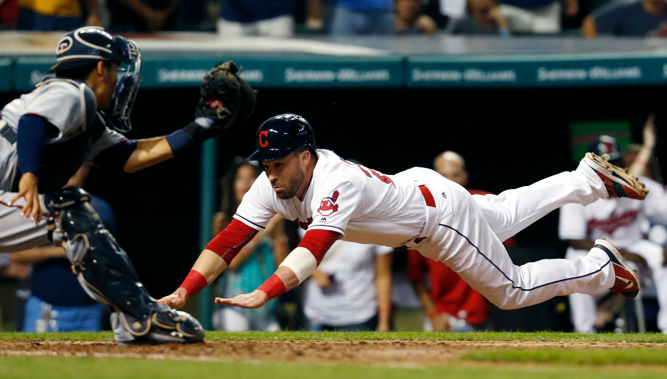Cleveland Indians' Jason Kipnis (22) dives into home plate and is tagged out by Minnesota Twins' Kurt Suzuki (8) on a ball hit by Francisco Lindor during the fourth inning of a baseball game Tuesday, Aug. 30, 2016, in Cleveland. (AP Photo/Ron Schwane)