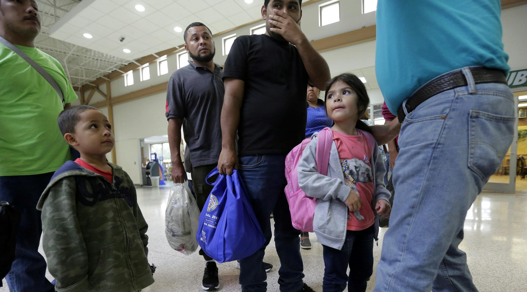 A group of immigrants from Honduras and Guatemala seeking asylum receive help the bus station after they were processed and released by U.S. Customs and Border Protection, Thursday, June 21, 2018, in McAllen, Texas. President Donald Trump signed an executive order to end family separations at the border.