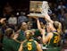 Park Center players celebrate with their championship trophy after defeating Marshall 52-45 in the Class 3A girls' basketball championship game on Sat