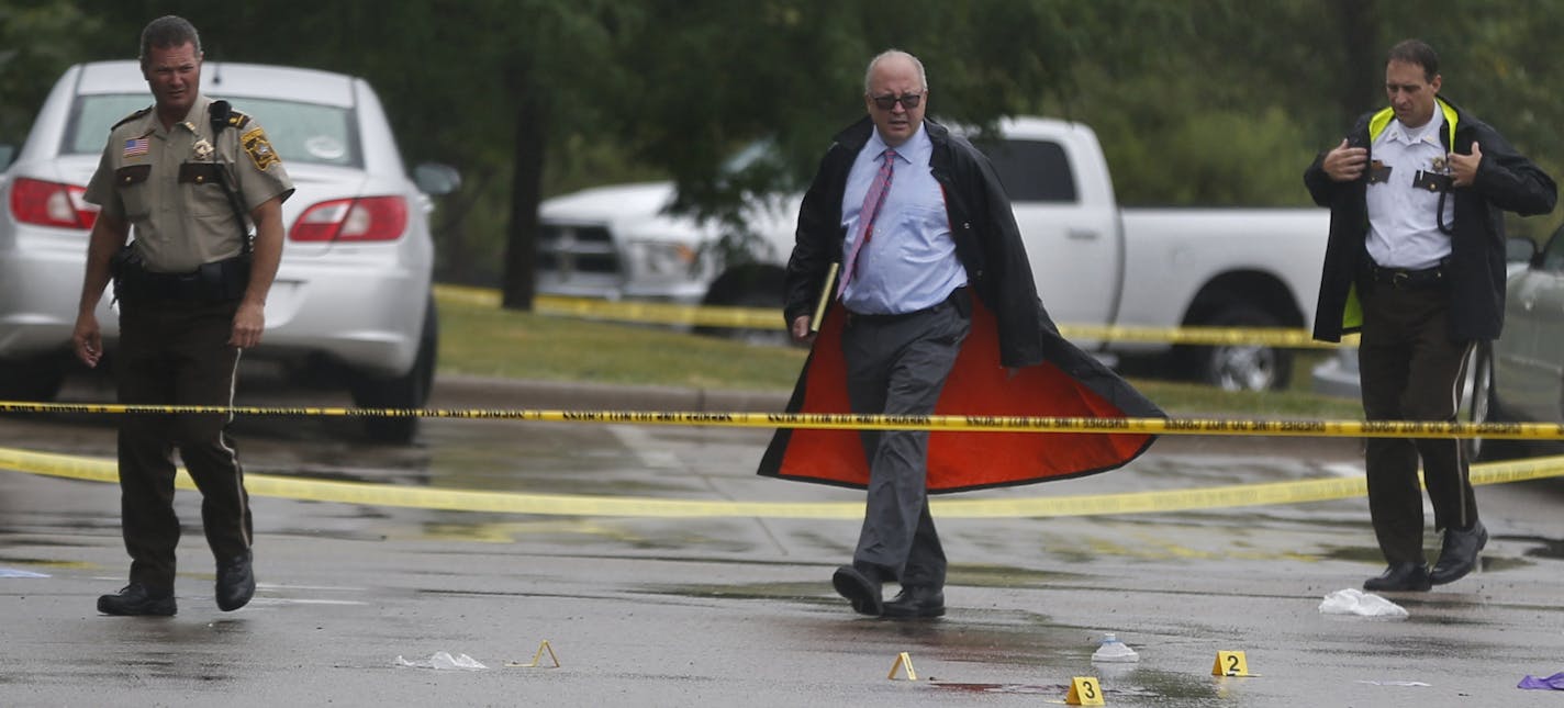 At the Holiday gas startion on HWY 96 near the the 35W exit in Arden Hills on Aug. 11, 2104, investigators examined the evidence at the site of a shooting. The suspect who drove away in a BMW is still at large . ] Richard Tsong-Taatarii/rtsong-taatarii@startribune.com