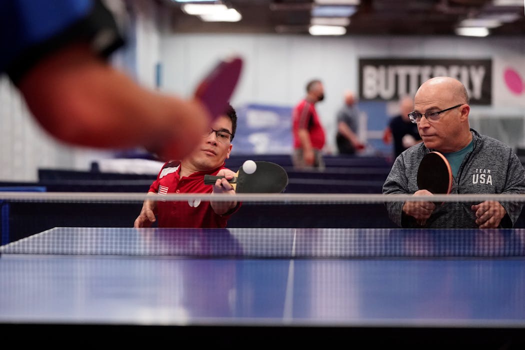 Ian Seidenfeld, left, with his father Mitchell Seidenfeld, right, at the Table Tennis Minnesota Training Center in South St. Paul in April. 