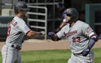 Minnesota Twins' Nelson Cruz, right, celebrates with Aaron Whitefield after hitting a three-run home run during the eighth inning of a baseball game a