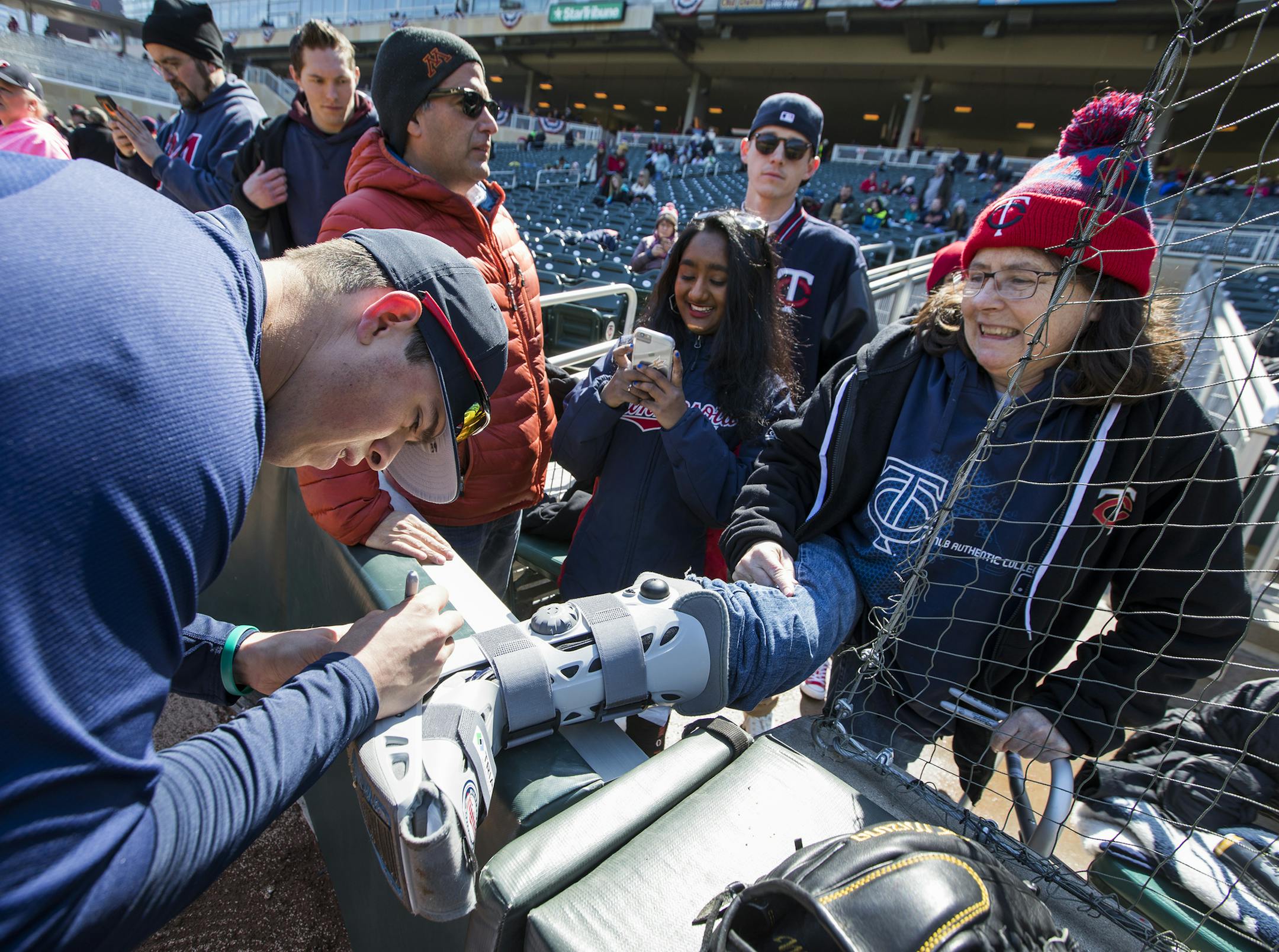 Patricia Rydeen of Minneapolis has her cast signed by Minnesota Twins relief pitcher Trevor Hildenberger before the team's home opener against the Seattle Mariners at Target Field in Minneapolis on Thursday, April 5, 2018. (Leila Navidi/Minneapolis Star Tribune/TNS) ORG XMIT: 1227871