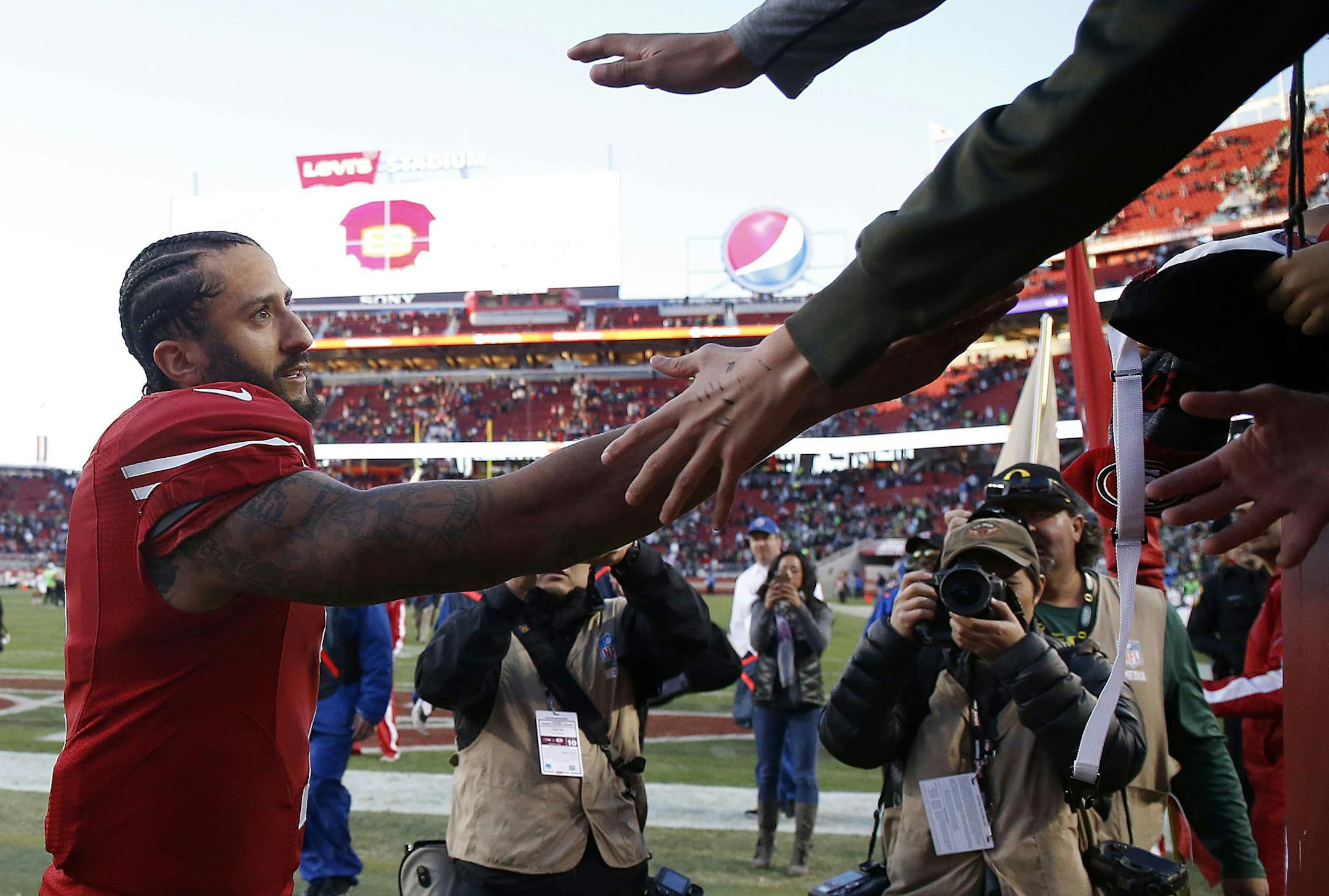 FILE - In this Jan. 1, 2017, file photo, San Francisco 49ers quarterback Colin Kaepernick greets fans after an NFL football game against the Seattle Seahawks in Santa Clara, Calif. It was his last game in the NFL.. (AP Photo/Tony Avelar, File)
