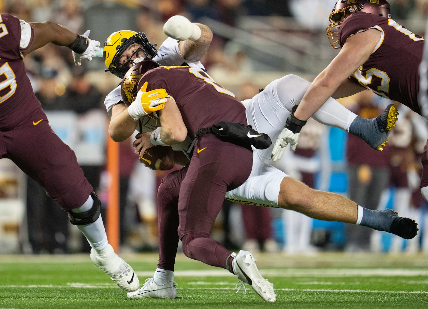 Michigan defensive lineman Mason Graham (55) tackles Minnesota quarterback Athan Kaliakmanis (8) in the third quarter Saturday, Oct. 07, 2023, at Huntington Bank Stadium in Minneapolis, Minn. ]