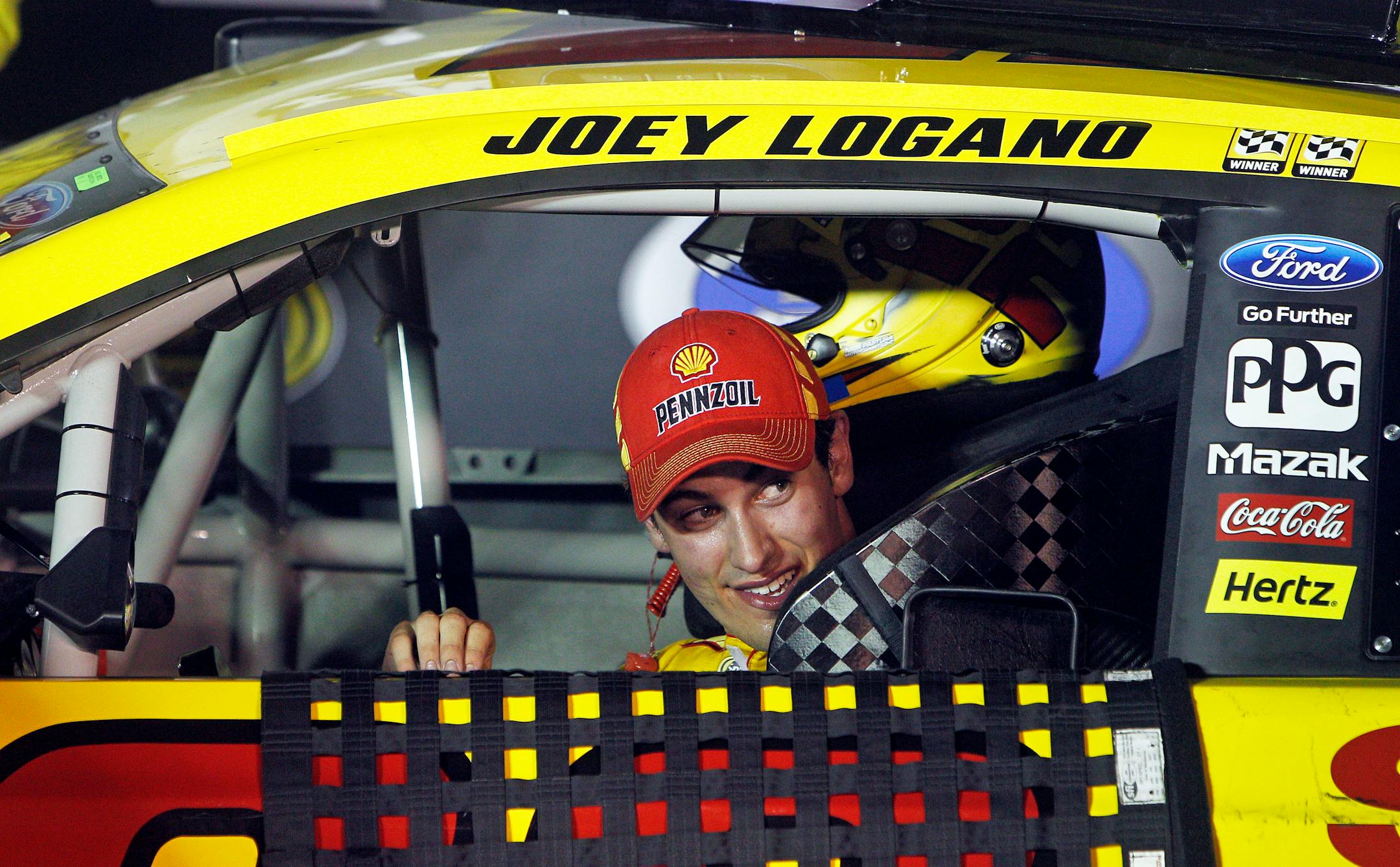 Driver Joey Logano peeks out his window as he pulls into victory lane after winning a NASCAR Sprint Cup Series auto race at Bristol Motor Speedway on Saturday, Aug. 23, 2014, in Bristol, Tenn. (AP Photo/Wade Payne)