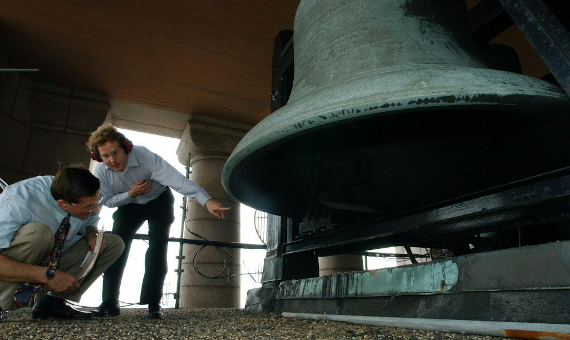 Joey McLeister/Star Tribune Minneapolis,Mn.,Fri.,July 2, 2004--(Left to right) Star Tribune reporter Dan Wascoe and Tony Hill, chair of the City Hall Carillon Committee, look inside one of the bells at City Hall.
GENERAL INFORMATION: Tony Hill, Chair of the City Hall Carillon Committee, gives a tour of the bells at Minneapolis City Hall.