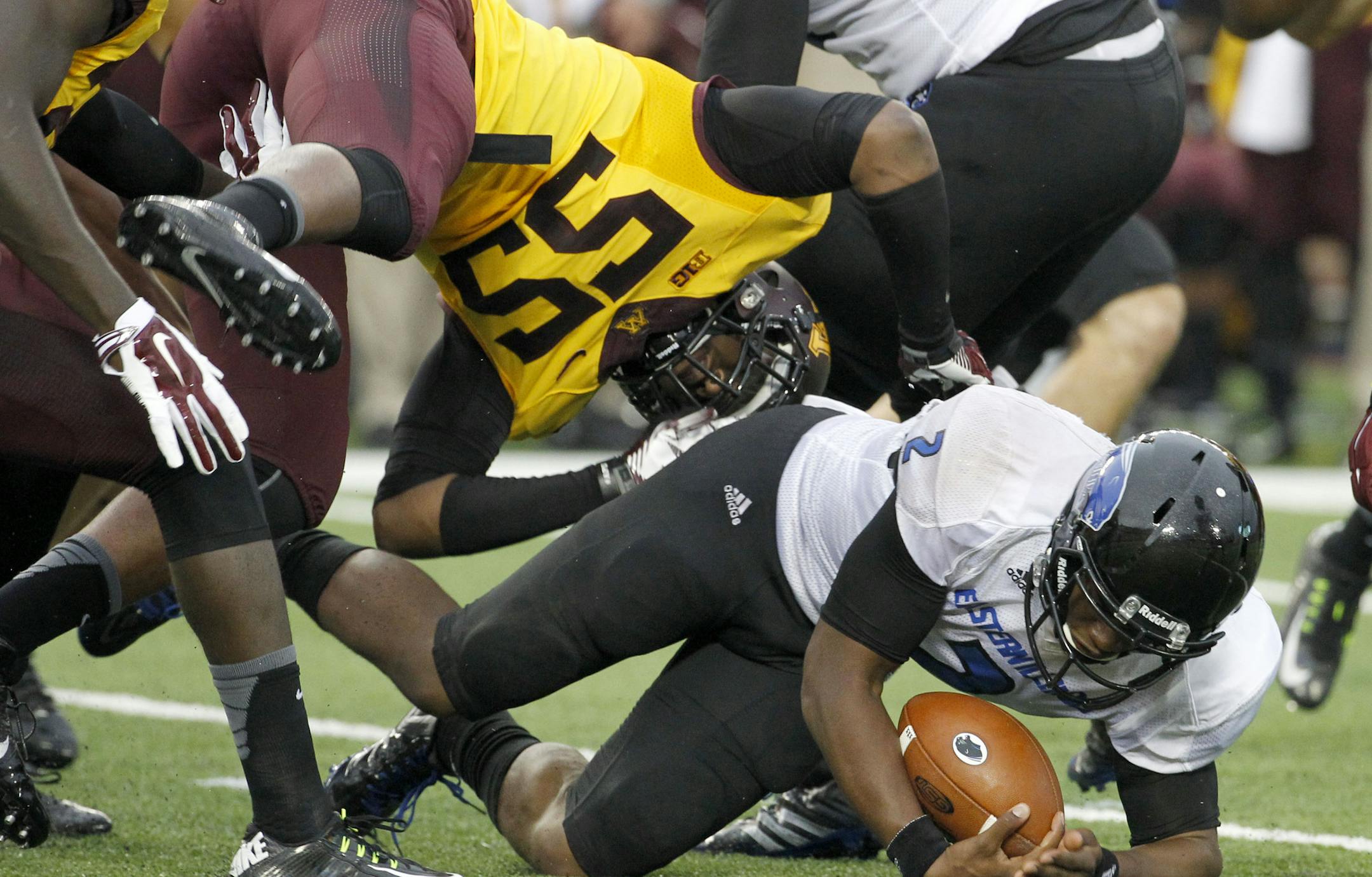 Eastern Illinois quarterback Jalen Whitlow, lands under Minnesota defensive lineman Theiren Cockran (55) after carrying the ball for a nine and 1/2-yard gain during the second quarter of an NCAA college football game in Minneapolis Thursday, Aug. 28, 2014. (AP Photo/Ann Heisenfelt) ORG XMIT: MIN2014082921154593