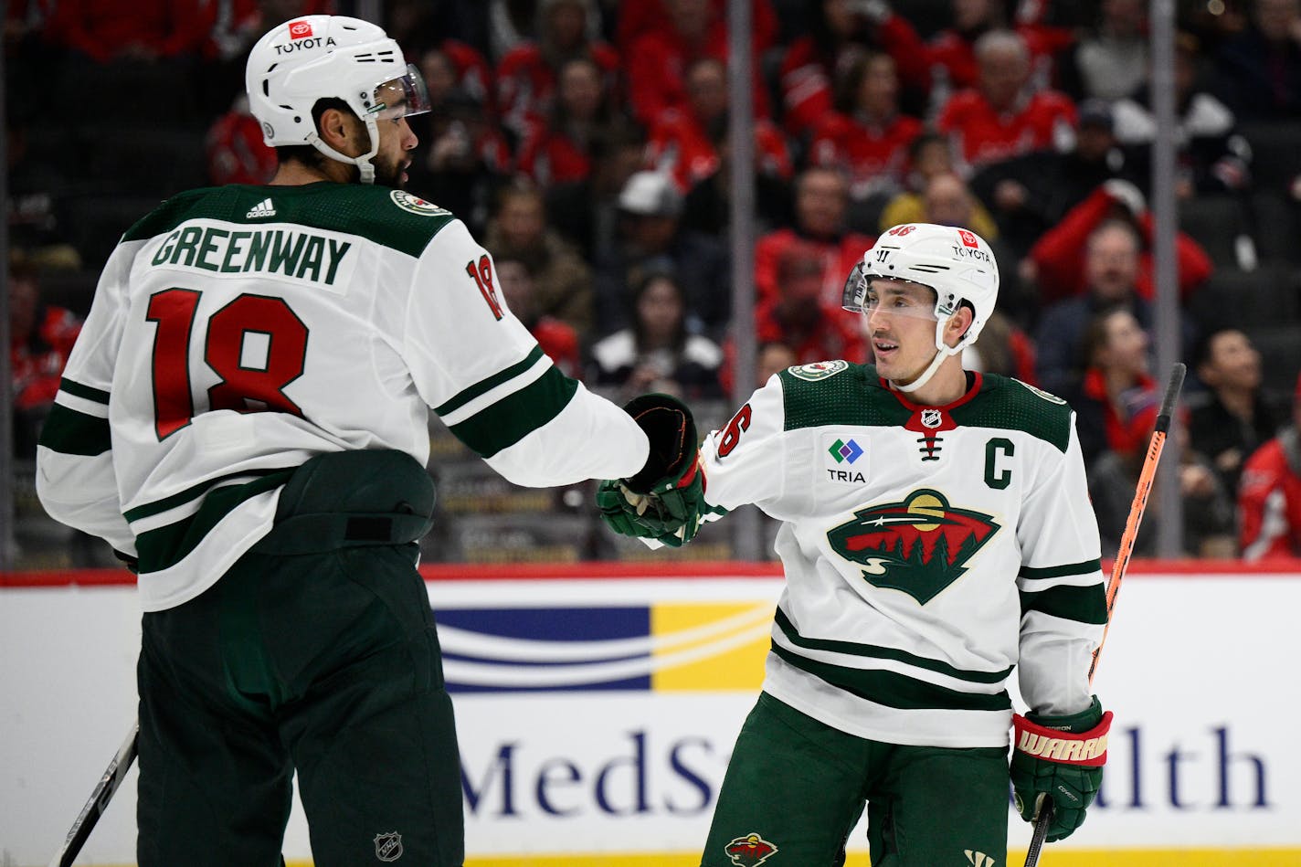 Minnesota Wild defenseman Jared Spurgeon (46) celebrates his goal with Minnesota Wild left wing Jordan Greenway (18) during the second period of an NHL hockey game against the Washington Capitals, Tuesday, Jan. 17, 2023, in Washington. (AP Photo/Nick Wass)