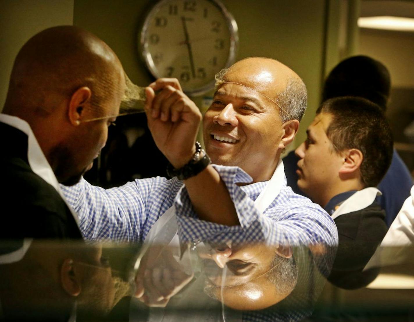 Minneapolis interim superintendent Michael Goar, along with some staff members, volunteered as a server at People Serving People Wednesday, June 17, in Minneapolis, MN. Here, Goar helped Michael Walker, director of the district's office of black male student achievement, with his hair net.