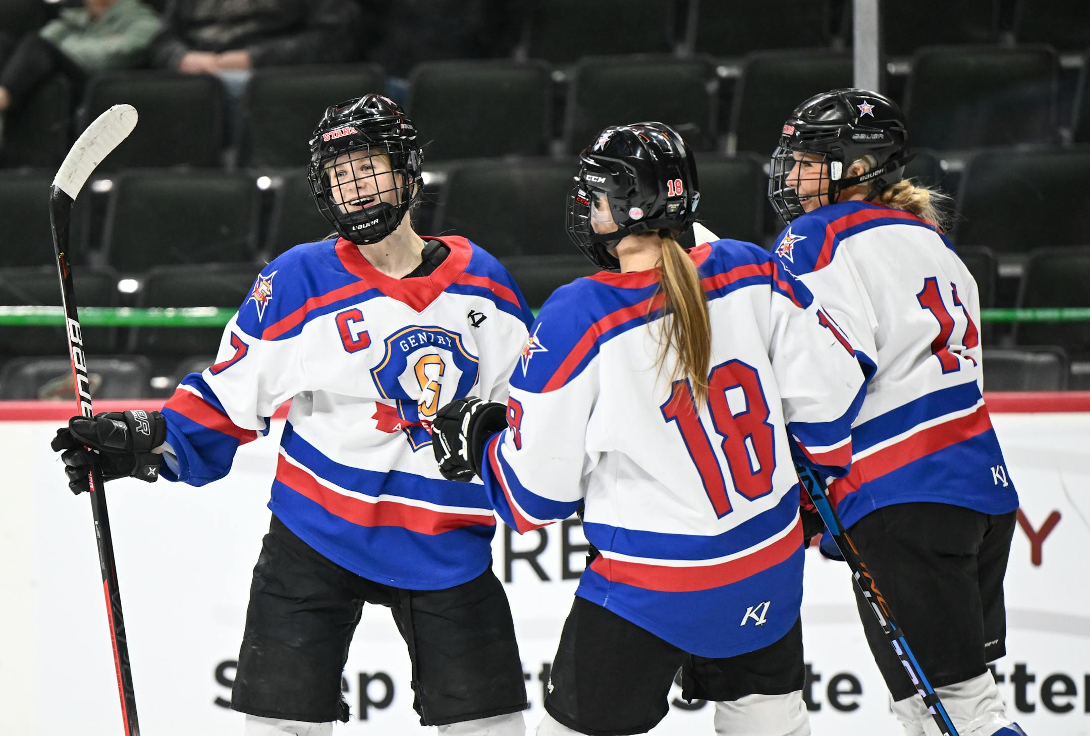 Gentry forward Ellie Sarauer (18) and defenseman Skylar Salscheider (11) celebrate with forward Cara Sajevic (7) after her second goal of the game against Moorhead during the first period.