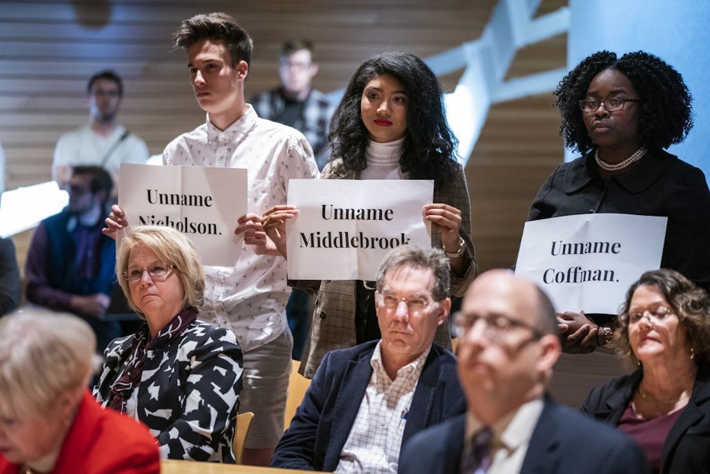 University of Minnesota students Ian Smith, from left, Chloe Williams and Jael Kerandi stand with signs during the vote.