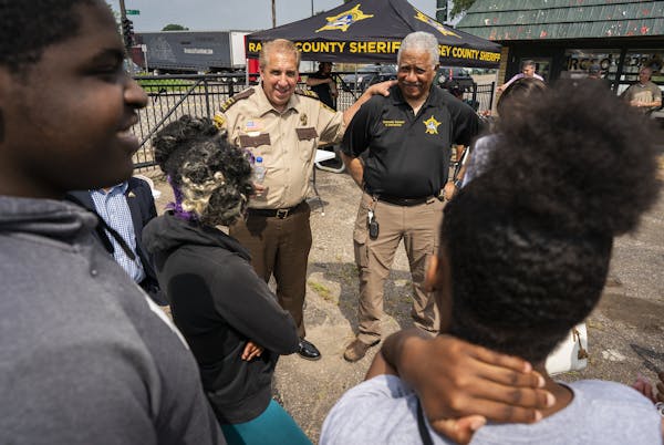 Ramsey County Sheriff Bob Fletcher, center left, and Undersheriff Bill Finney talked with teens during the substation's grand opening Monday.