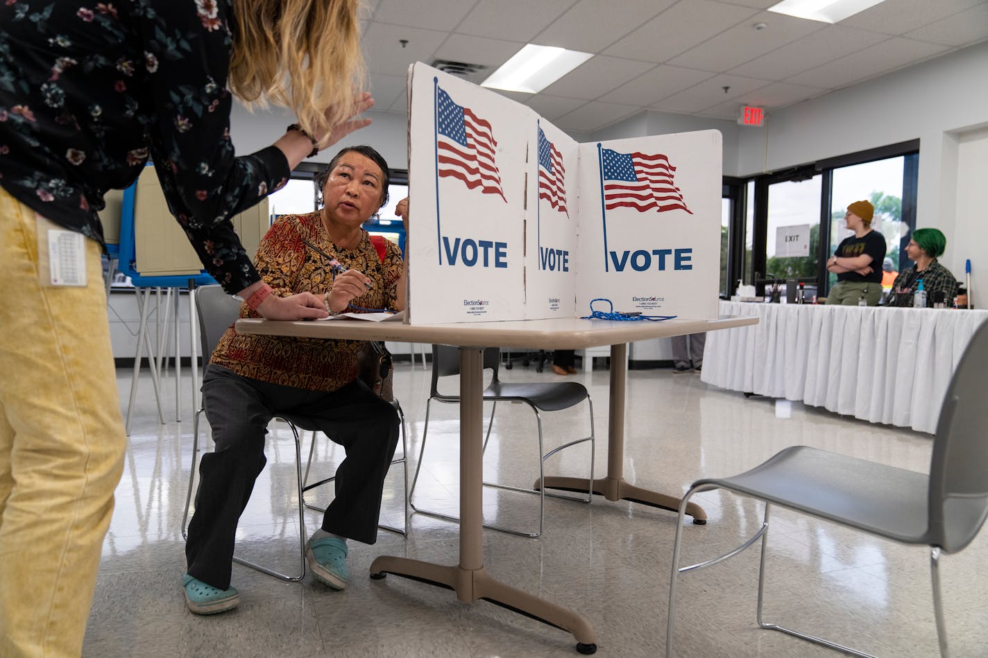 Pa Lee gets assistance from election staff while filling out her ballot during the first day of early voting at Minneapolis Elections &amp; Voter Services in Minneapolis, Minn. on Friday, Sept. 22, 2023. ] LEILA NAVIDI • leila.navidi@startribune.com