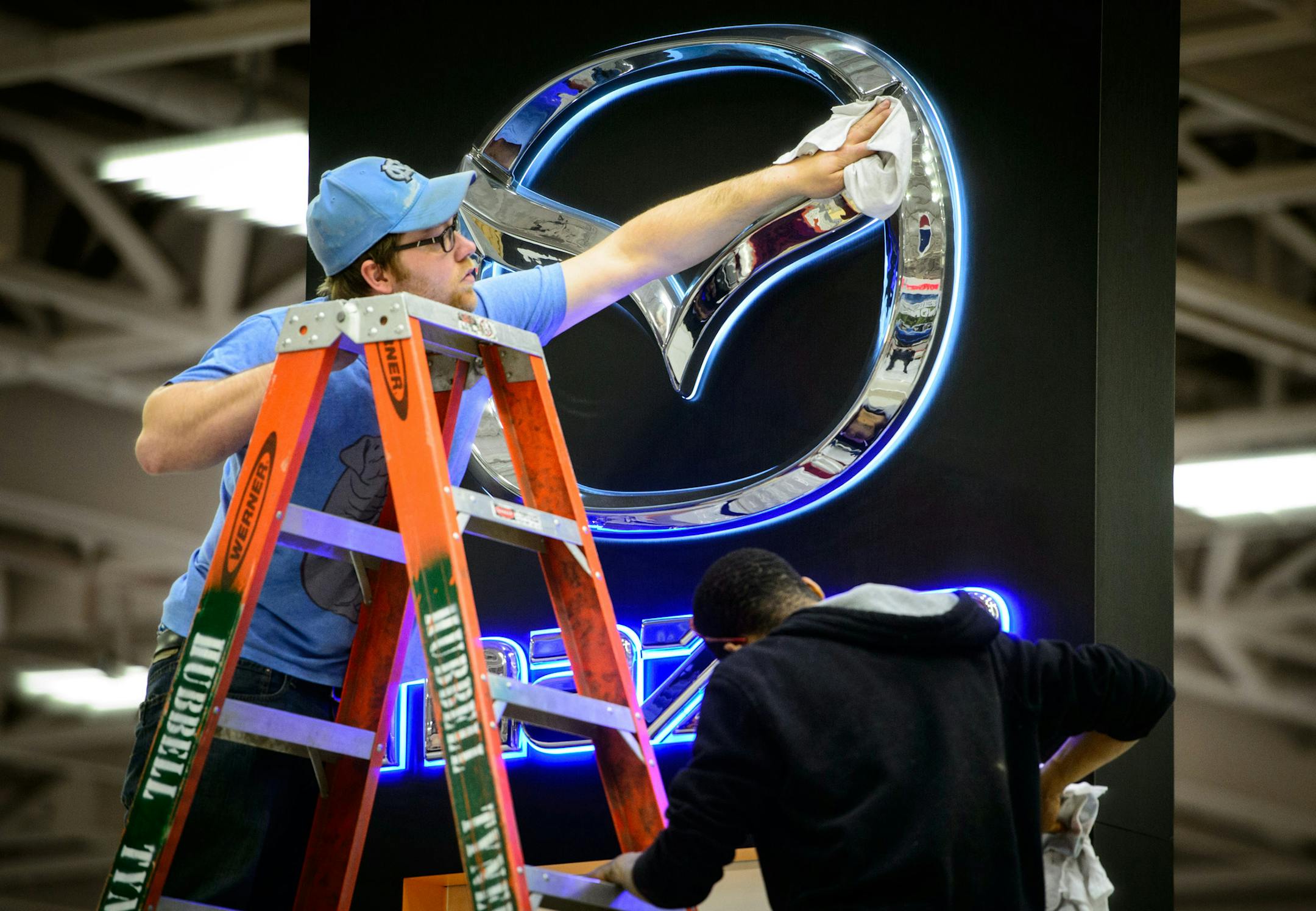 Adam Bick, left and Ozzie Echols polished the Mazda display. ] GLEN STUBBE * gstubbe@startribune.com Friday March 7, 2014 The Twin Cities Auto Show runs through March 16.