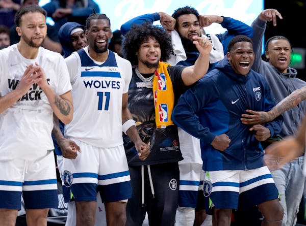 As the Wolves close out Monday's victory in Denver, the team bench cheers reserves playing out the game.