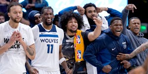 As the Wolves close out Monday's victory in Denver, the team bench cheers reserves playing out the game.