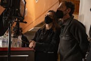 photograph of filmmakers Tricia Cooke and Ethan Coen, masked, on set