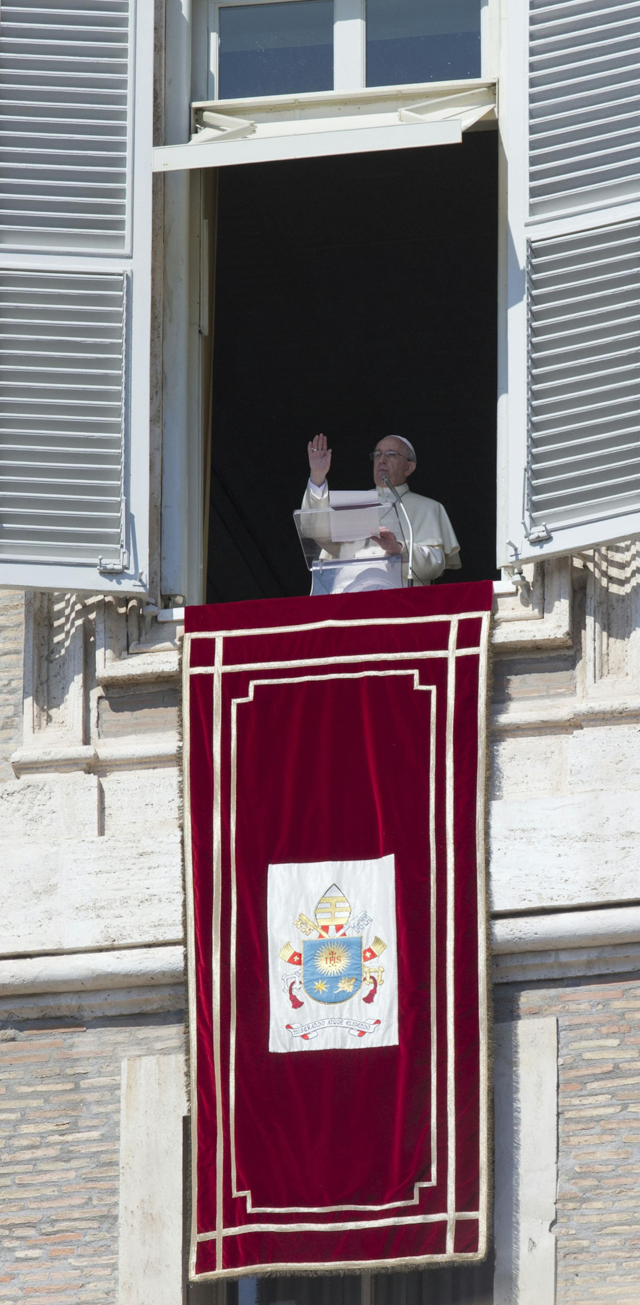 Pope Francis delivers his blessing during the Angelus noon prayer he celebrated from the window of his studio overlooking St. Peter's Square, at the Vatican, Sunday, March 9, 2014. (AP Photo/Andrew Medichini)