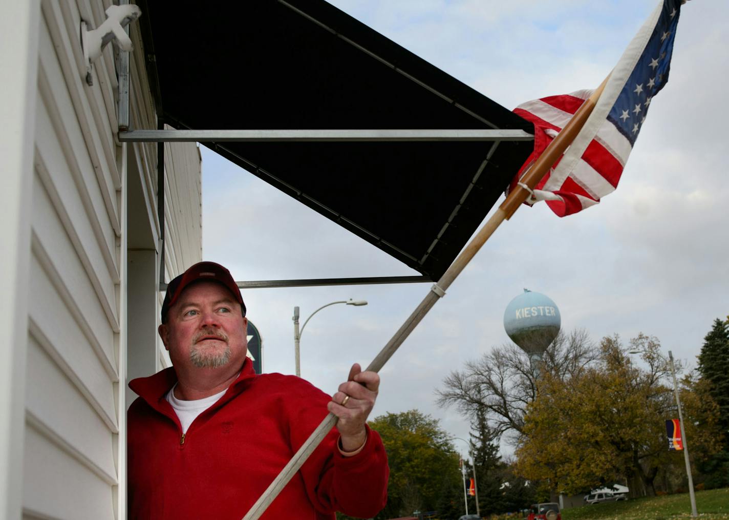 At the end of a day, Mike Sandt took in the flag in front of the Kiester, MN post office. Tuesday, October 29, 2013. ] GLEN STUBBE * gstubbe@startribune.com ORG XMIT: MIN1310301921114986