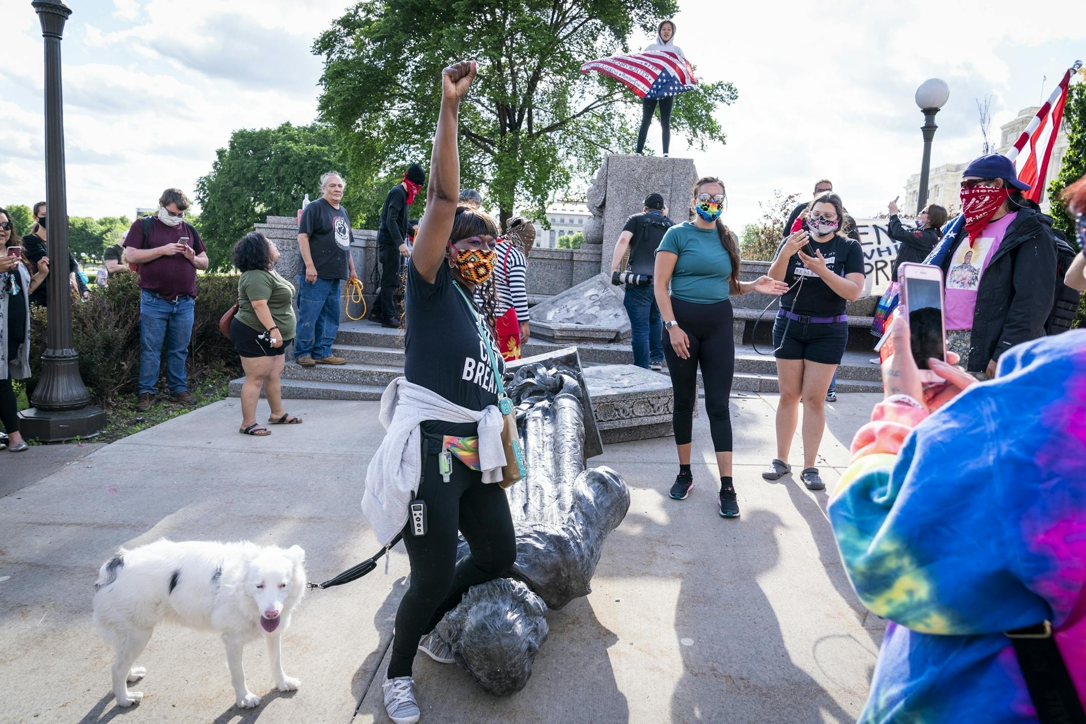 Genether Thornton, of St. Paul posed for photos with her knee on the neck of the Christopher Columbus statue after it was toppled.