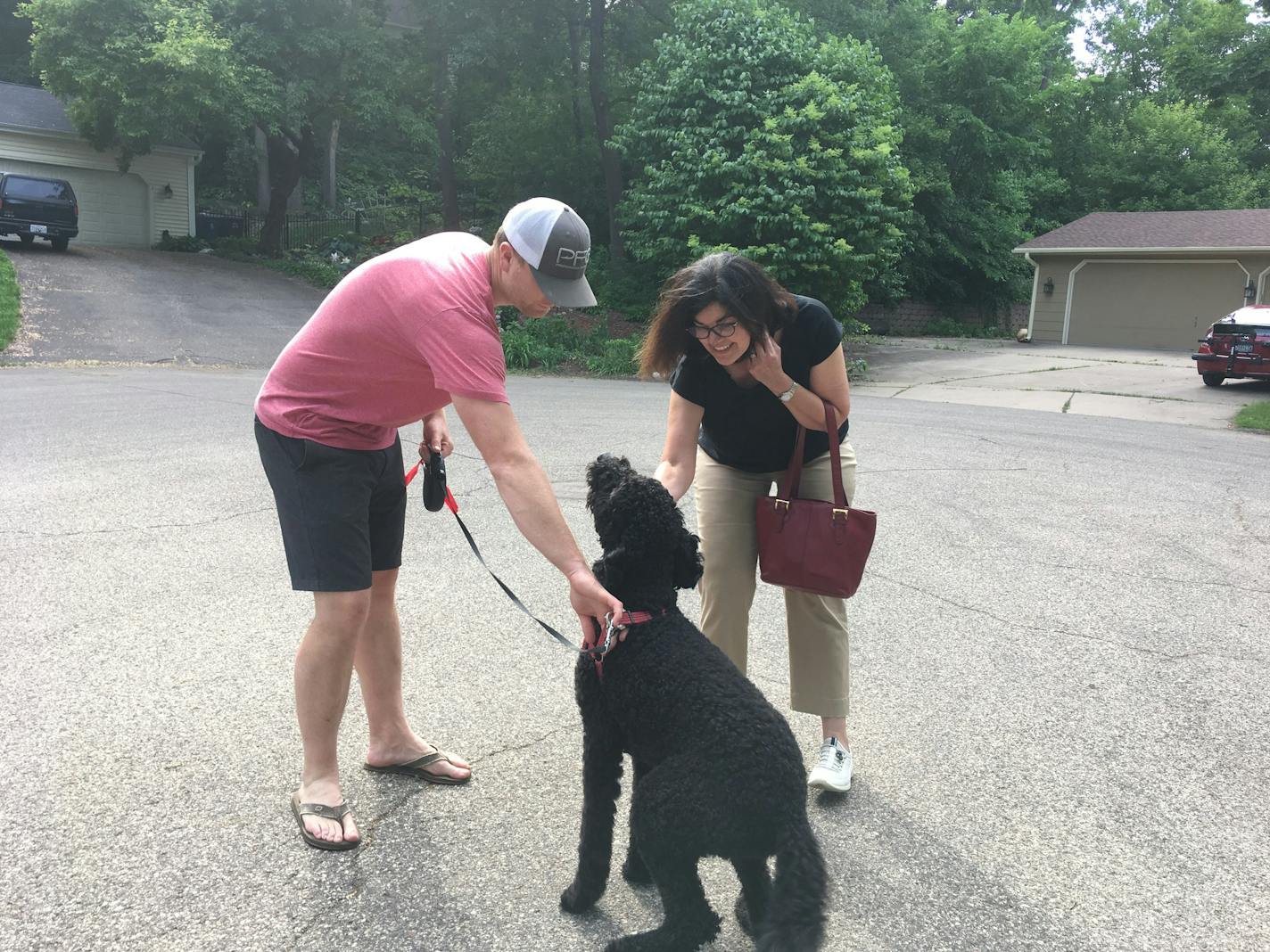 Ellen Cousins, a first-time candidate for the Minnesota House, stops to pet her neighbor's dog on her way home from doorknocking in her Minnetonka neighborhood Thursday.