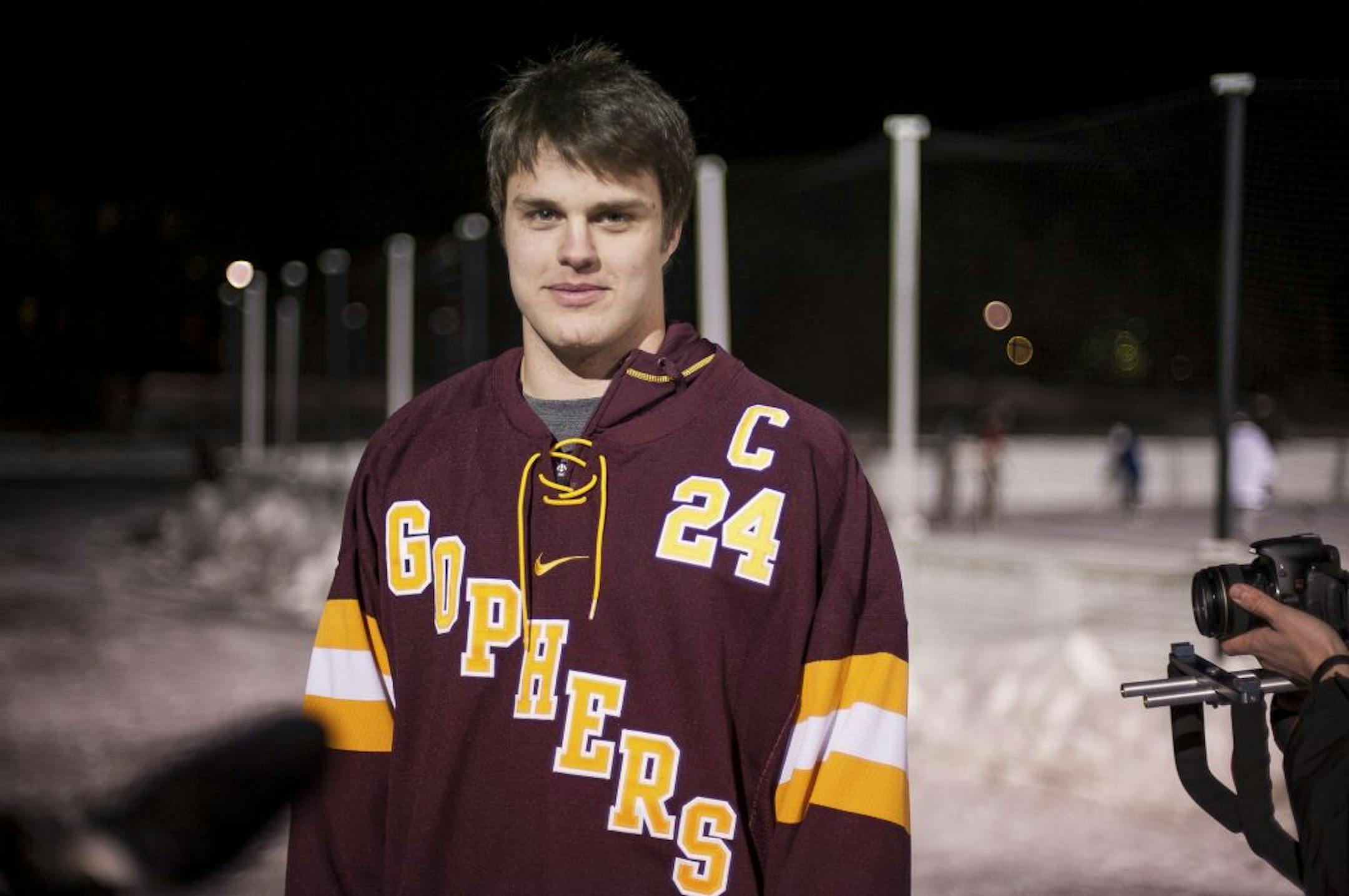 Gophers forward Zach Budish presents the team's commemorative jersey for this weekend's outdoor game in Chicago.