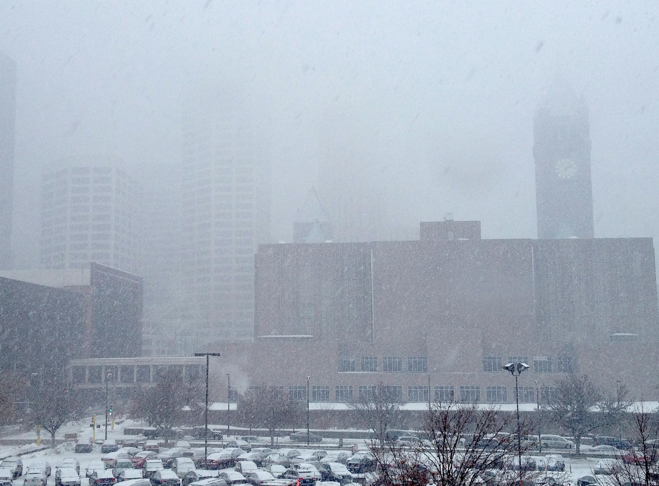 Snow and poor visibility have descended on downtown Minneapolis at midday Thursday, Feb. 20, 2014, the beginning of an expected major snowstorm.