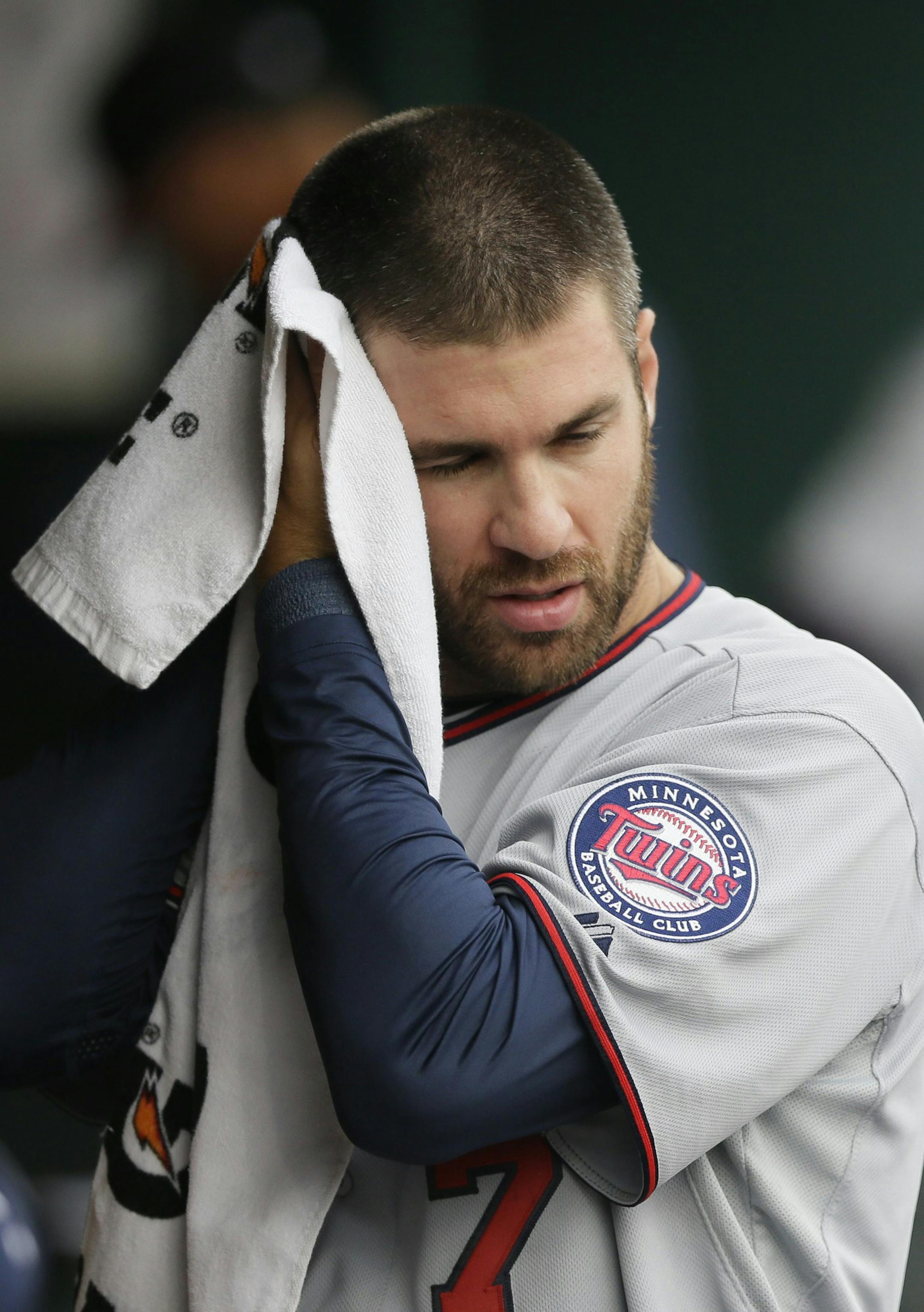 Minnesota Twins first baseman Joe Mauer is seen in the dugout during the fourth inning of a baseball game against the Detroit Tigers, Thursday, April 9, 2015, in Detroit. (AP Photo/Carlos Osorio)