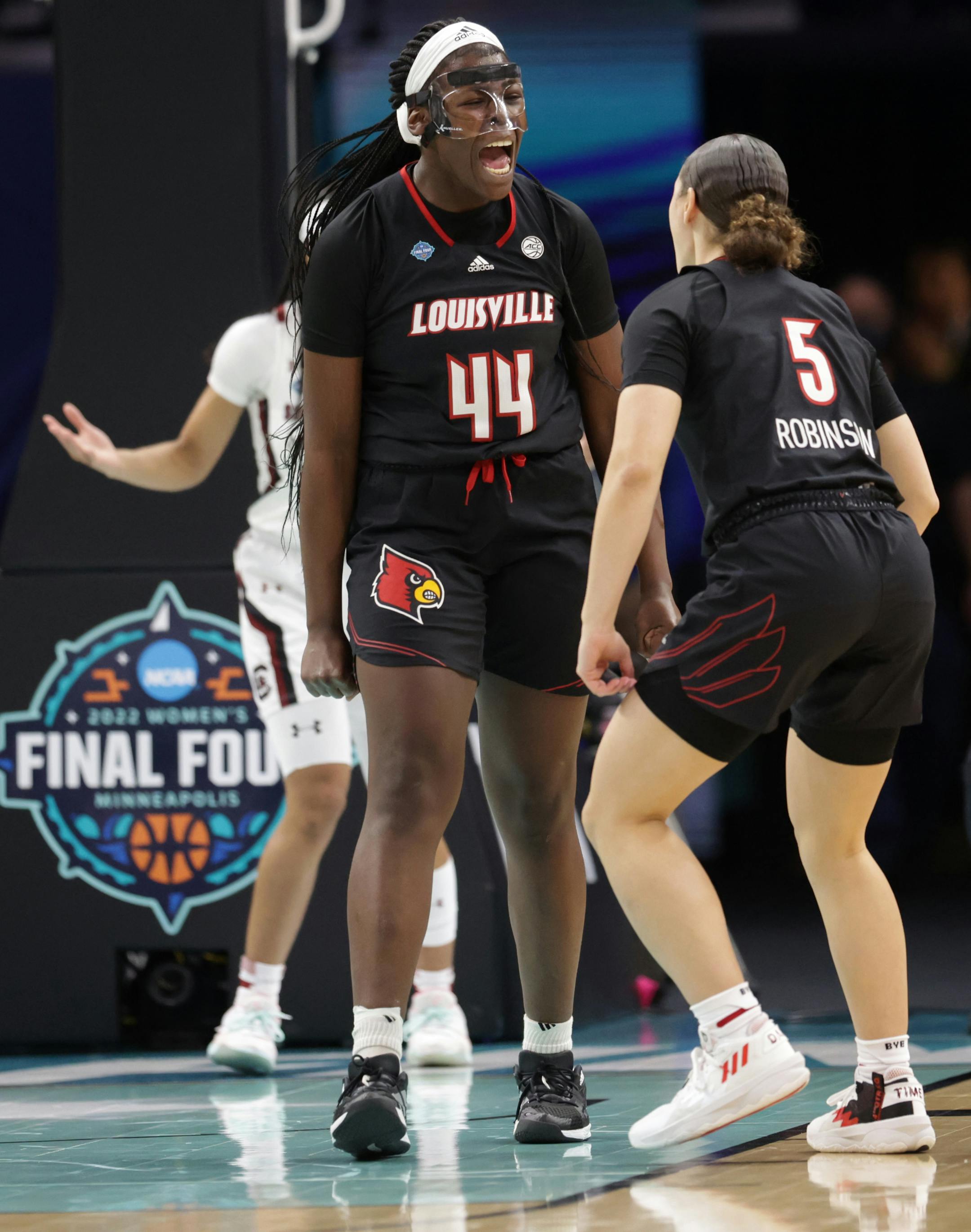Louisville forward Olivia Cochran reacts after being fouled on a basket with Louisville guard Mykasa Robinson.