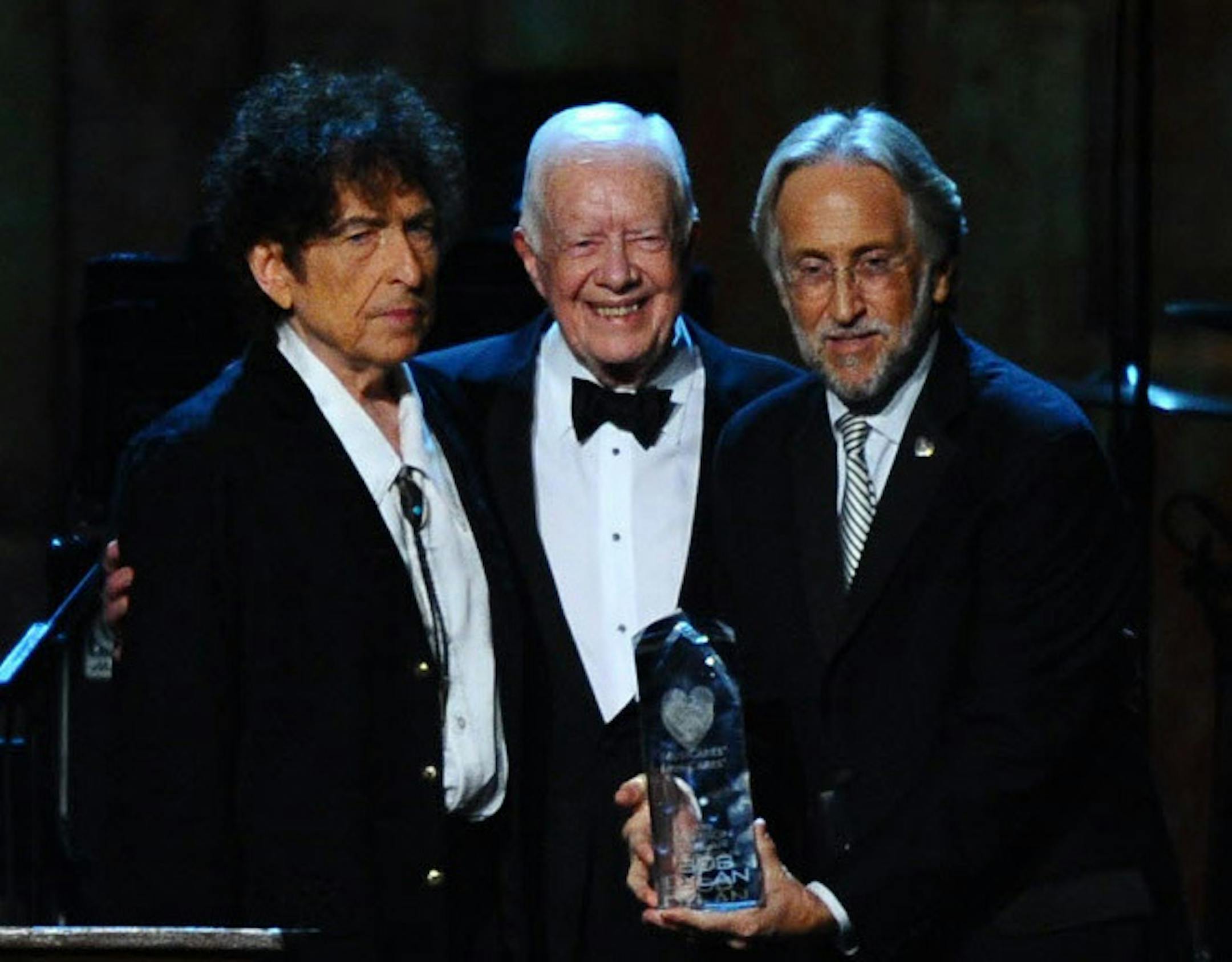 From left, President Jimmy Carter, Bob Dylan and Neal Portnow, President/CEO of The Recording Academy and President of The MusiCares Foundation, at the 2015 MusiCares Person of the Year show at the Los Angeles Convention Center on Friday, Feb. 6, 2015, in Los Angeles.