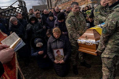 Relatives and friends mourn the body of senior police sergeant Roman Rushchyshyn in the village of Soposhyn, outskirts of Lviv, western Ukraine, Thursday, March 10, 2022, in Lviv. Rushchyshyn, a member of the Lviv Special Police Patrol Battalion, was killed in the Luhansk Region.