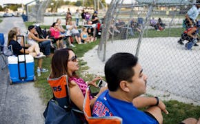 From left, Marilu Arce and her husband Raul Arce watch their daughter Alyssa Arce, 17, play softball at Bettenhausen Park on Tuesday, Aug. 1, 2017 in 
