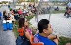 From left, Marilu Arce and her husband Raul Arce watch their daughter Alyssa Arce, 17, play softball at Bettenhausen Park on Tuesday, Aug. 1, 2017 in 