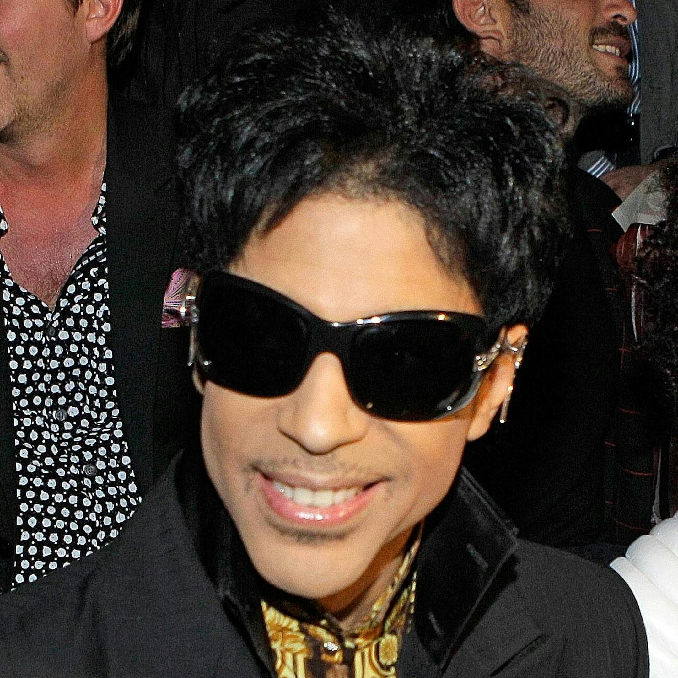 Singer Prince and his date are shown seated before the start of the Versace for H&M fashion show in New York, Tuesday, Nov. 8, 2011. (AP Photo/Kathy Willens) ORG XMIT: MIN2013040117084859
