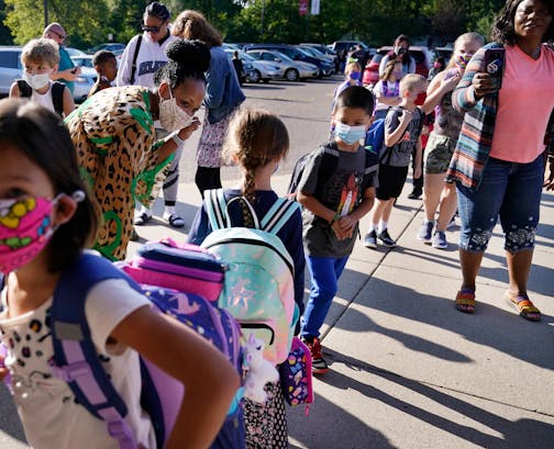 New Hoover Elementary School principal Keisha Davis greeted students and parents outside the school before the start of the school day on the first day of school Tuesday in Coon Rapids.   ]