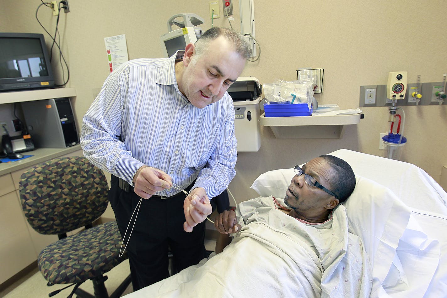 Fouad Bachour, MD, spoke and showed the CardioMem, a new St. Jude product, to patient Joe Jones before implanting it into him at Hennepin County Medical Center, Thursday, February 26, 2015 in Minneapolis, MN. St. Jude had a big day on Thursday, as HCMC implanted Minnesota's first CardioMems remote-monitoring devices in local patients' hearts since FDA approval last fall. ] (ELIZABETH FLORES/STAR TRIBUNE) ELIZABETH FLORES &#x2022; eflores@startribune.com