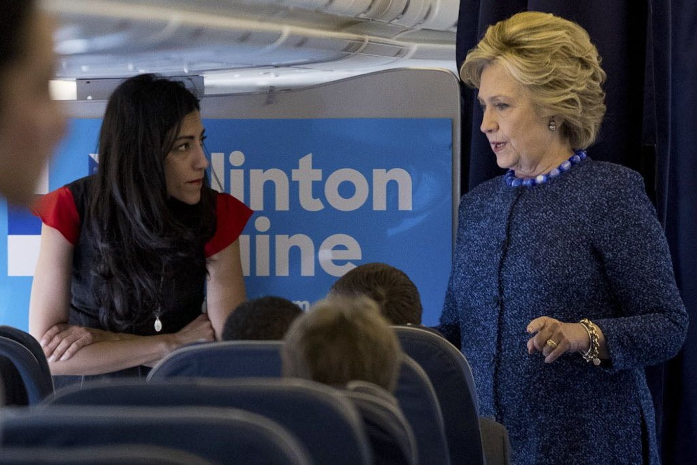 Democratic presidential candidate Hillary Clinton speaks with senior aide Huma Abedin aboard her campaign plane at Westchester County Airport in White Plains, N.Y., Friday, Oct. 28, 2016, before traveling to Iowa for rallies.