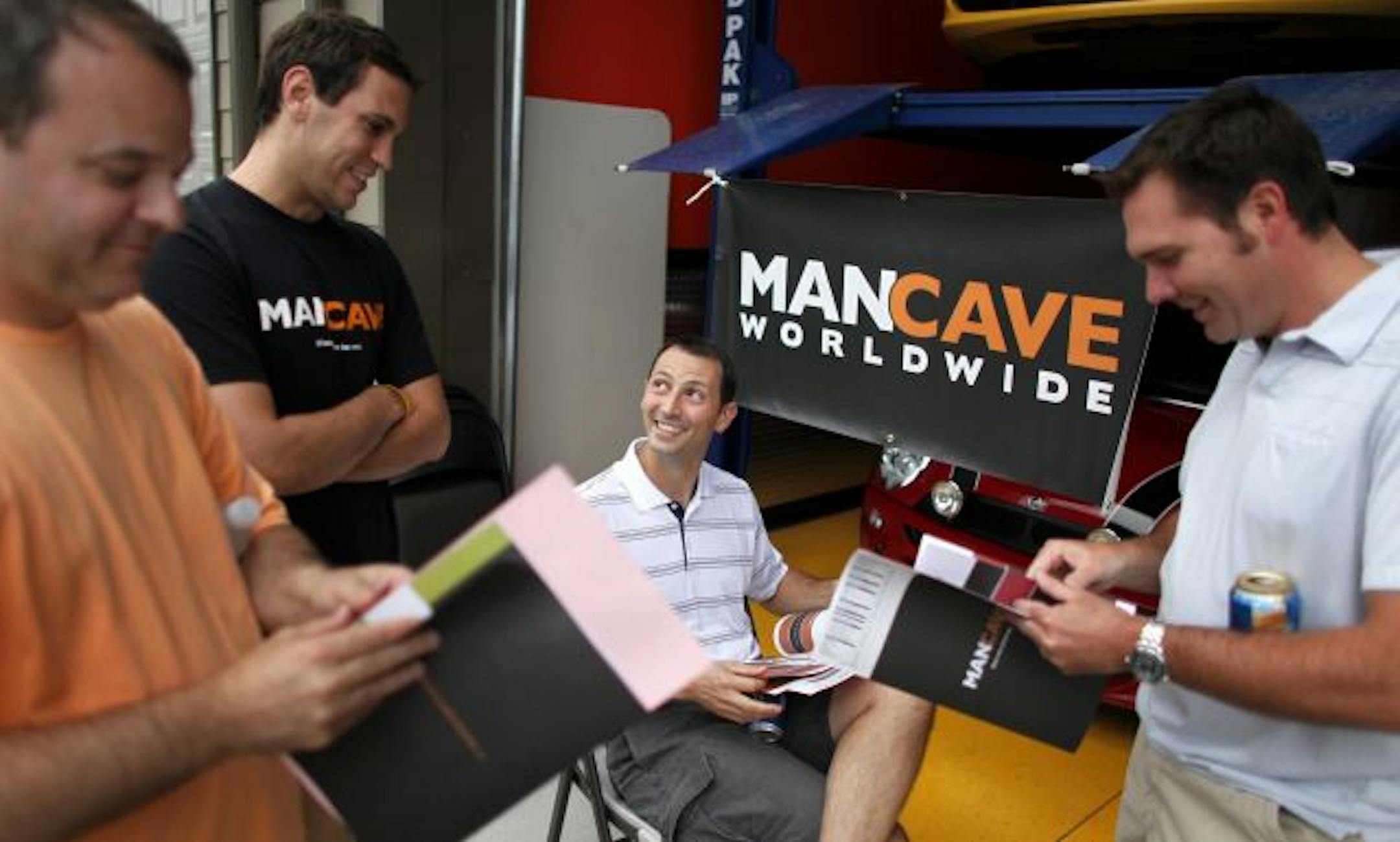 Man Cave founder Nick Beste, second from left, talks with John Turcotte, center, of St. Louis Park during a recent ManCave party in Chanhassen. ManCave products, pictured below, range from poker tables and supplies to cooking and grilling ware.