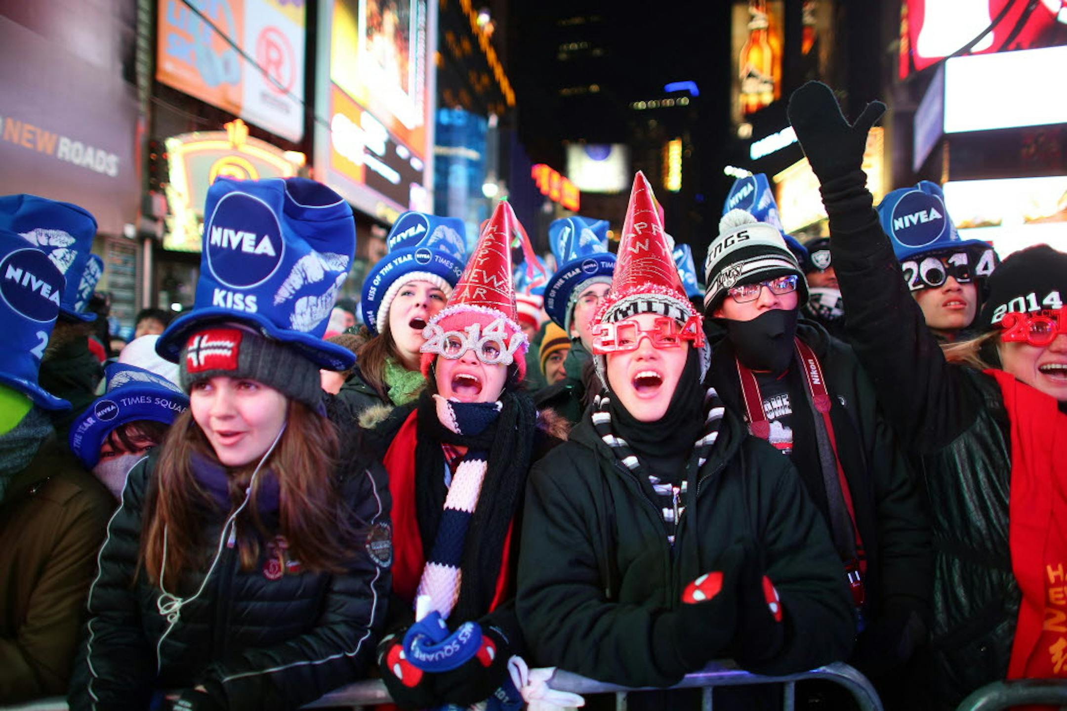 Ashley Martinez, 20, second from left, and Jesse Padilla, 14, participate in New Year's Eve festivities at Times Square in New York, Dec. 31, 2013.