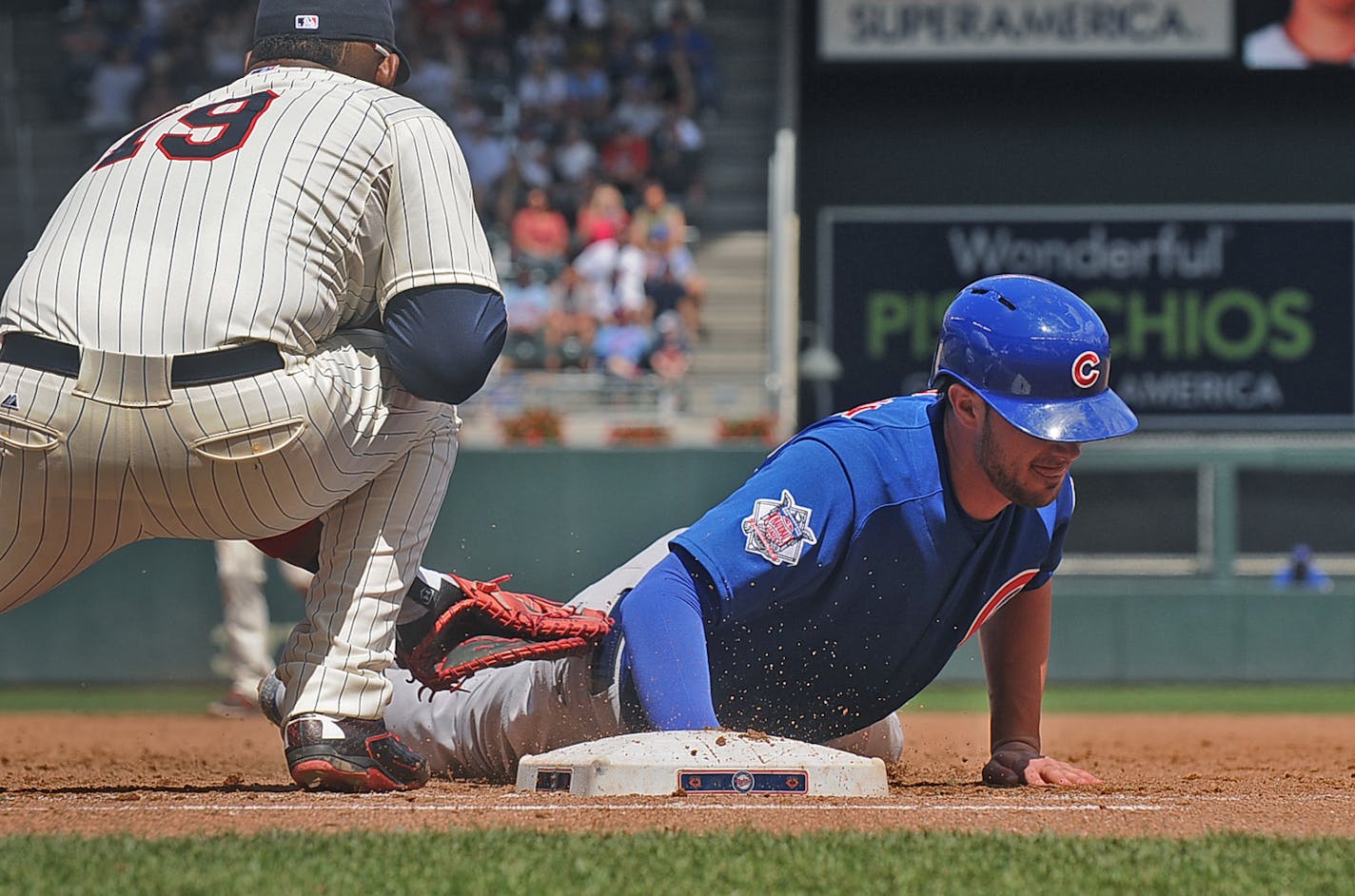 Cubs base runner Kris Bryant just makes it back to first base under the tag of Minnesota's Kennys Vargas on a pickoff attempt in the sixth inning of a baseball game, Saturday June 20, 2015, in Minneapolis. Chicago won 4-1 in 10 innings. (AP Photo/Richard Marshall)