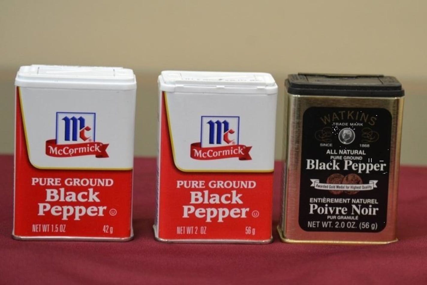 Photo showing traditional McCormick Small Tins with 1.5-ounce slack-fill and with traditional 2-ounce fill along with Watkins tin with 2-ounce fill. (PRNewsFoto/Watkins Incorporated)